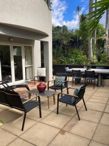a group of chairs and tables on a patio at Orakei Oasis Private Suite in Auckland
