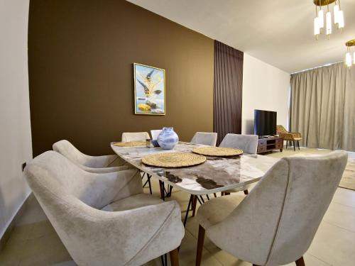a dining room with a table and chairs at Harf-RAW502 Large 2BHK Near ADNEC in Abu Dhabi