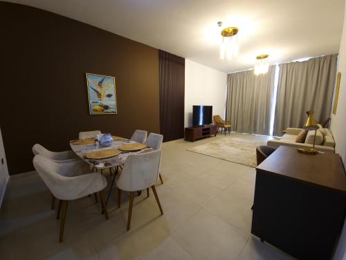 a living room with a table and chairs and a couch at Harf-RAW502 Large 2BHK Near ADNEC in Abu Dhabi