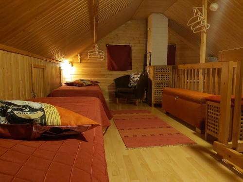 a bedroom with two beds and a chair in a cabin at AnriStar in Äkäslompolo
