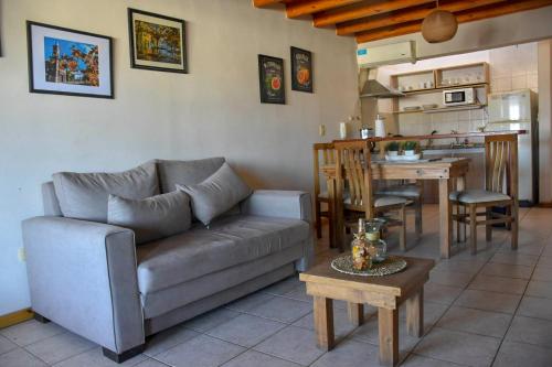 a living room with a couch and a table and a kitchen at Edificio Mitre in Maipú