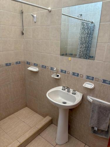 a bathroom with a sink and a shower with a mirror at Edificio Mitre in Maipú