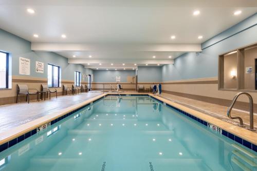 a swimming pool in a gym with chairs and tables at Holiday Inn Express and Suites Missoula by IHG in Missoula