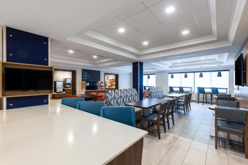 a restaurant with tables and chairs and a flat screen tv at Holiday Inn Express and Suites Missoula by IHG in Missoula