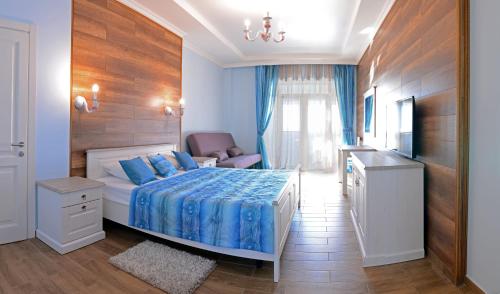 a bedroom with a bed with blue sheets and a television at Marseille Resort in Zatoka