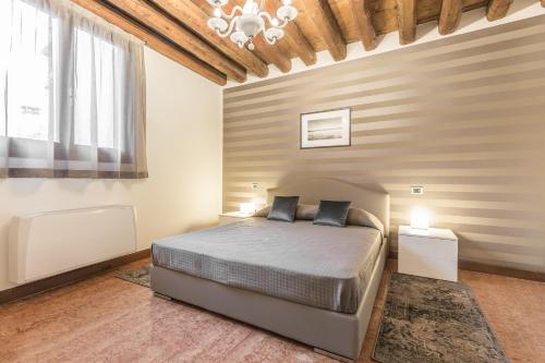 um quarto com uma cama e um lustre em Ca' del Monastero 6 Collection Chic Apartment for 4 Guests with Lift em Veneza