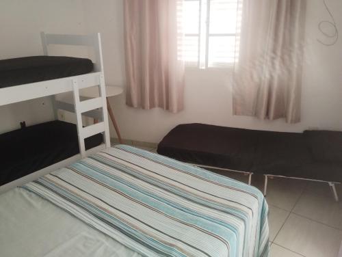 une chambre avec deux lits superposés et une fenêtre dans l'établissement Elaine, à Cachoeira Paulista