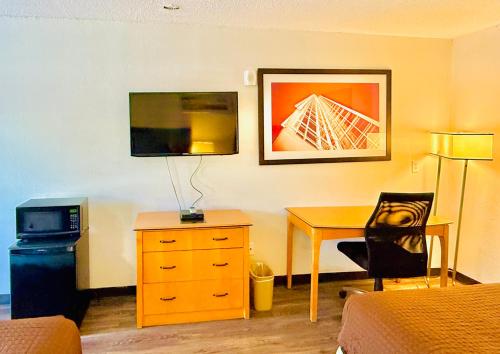 a hotel room with a desk and a bed and a room with a bed at Woodbridge Inn By OYO Rome in Rome