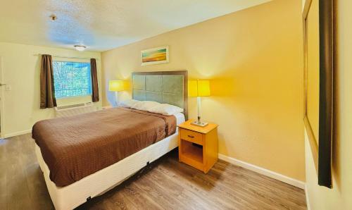 a bedroom with a bed and a table with a lamp at Woodbridge Inn By OYO Rome in Rome