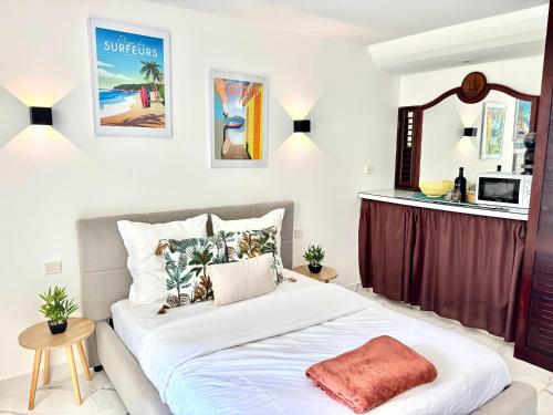 una camera da letto con un grande letto bianco e uno specchio di Studio bohème a La Trinité