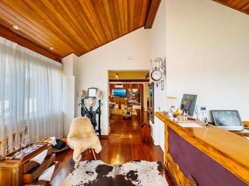a living room with a desk and a computer in it at Pousada Ville Le Mont - Campos do Jordao in Campos do Jordão
