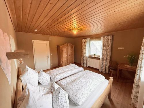 a bedroom with a large bed with a wooden ceiling at Sonnenplatz Appartment Ploninger NATUR in Bad Kleinkirchheim