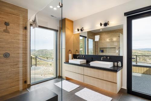 a bathroom with two sinks and a large mirror at Stunning Luxury Interiors, Jordanelle Views, Private Hot Tub, Sauna, Elite Locale! in Francis