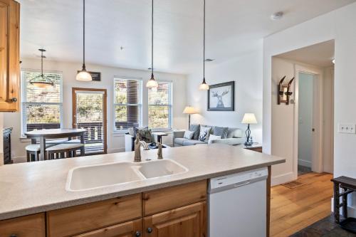 a kitchen with a sink and a living room at Summit Sanctuary, Sleeps 4, Charming Interiors, 20 Minutes from the Mountain! in Gorgosa