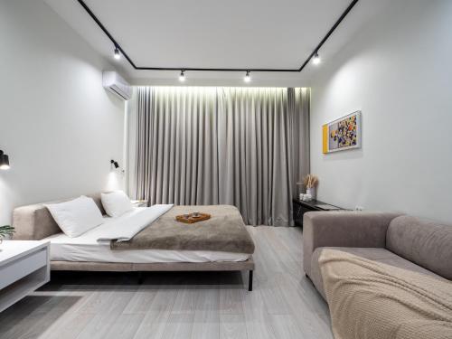 a bedroom with a bed and a couch at Seven Premium Apartments by Mega Mall in Almaty