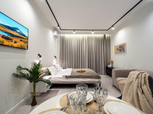 a living room with a bed and a couch at Seven Premium Apartments by Mega Mall in Almaty