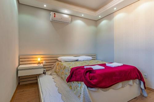 a bedroom with a bed with a red blanket at Imóvel bem localizado em Canela, cobertura in Canela