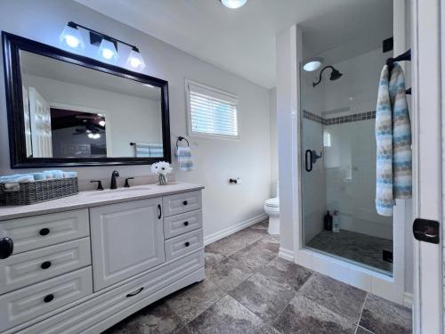 a bathroom with a sink and a shower with a mirror at Destination #13 in Anaheim