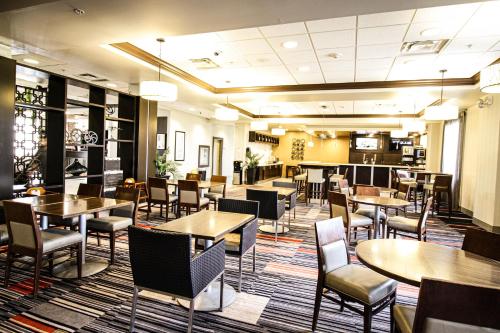 a restaurant with tables and chairs in a room at Waterloo Suites Hotel, Trademark Collection by Wyndham in Waterloo