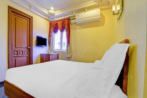 蒂鲁奇奇拉帕利Hotel O Royal的卧室里有一张白色的大床和一扇窗户