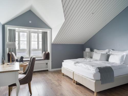 a bedroom with a bed and a desk and a window at Siglo Hotel by Keahotels in Siglufjörður
