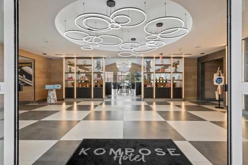 a lobby with a chandelier and a checkerboard floor at Kompose Boutique Hotel Houston Cy-Fair in Houston
