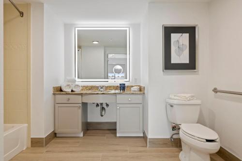 a bathroom with a sink and a toilet and a mirror at Kompose Boutique Hotel Houston Cy-Fair in Houston