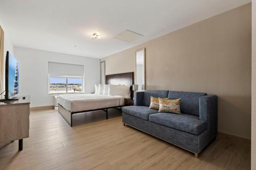 a bedroom with a bed and a couch and a bed at Kompose Boutique Hotel Houston Cy-Fair in Houston