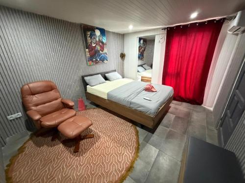 a small bedroom with a bed and a chair at Mai Hotel in Conakry