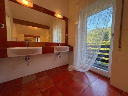 een badkamer met 2 wastafels en een groot raam bij Apartamenty Czyrna przy Gondoli in Szczyrk