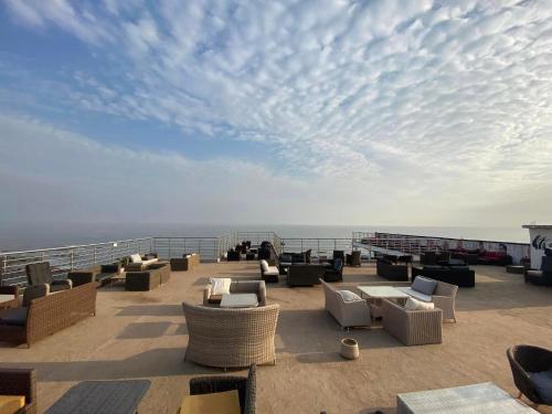 a patio with couches and chairs on a balcony at Mai Hotel in Conakry