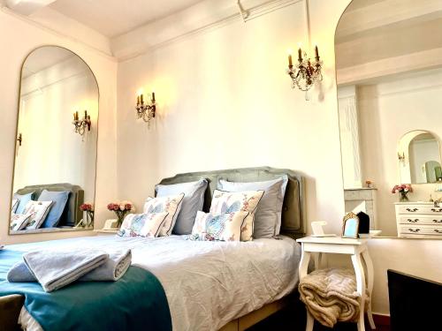 a bedroom with a bed with pillows and a mirror at L'escalier gaucher in Lambesc