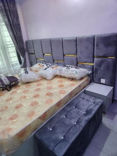 a bedroom with a large bed with blue padding at Yinmic Homes in Ikorodu