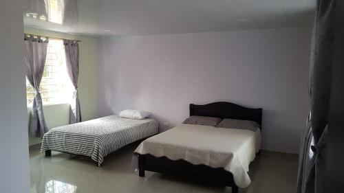 ein Schlafzimmer mit zwei Betten und einem Fenster in der Unterkunft Greenforest 