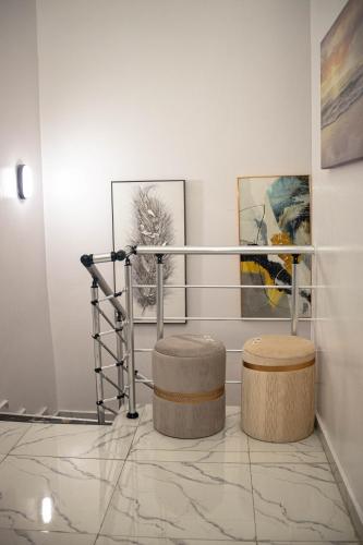 a room with two stools and paintings on the wall at City Escape in Ikuata