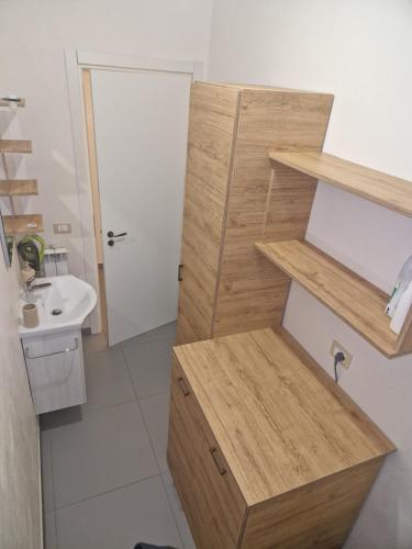 a bathroom with a sink and a wooden cabinet at Nina's house, nonno pepè in Isca Marina