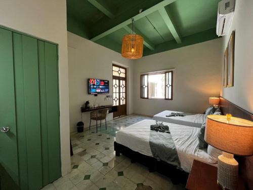 a bedroom with two beds and a green door at Hotel Boutique Santa Elena in Mérida