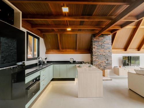 a kitchen with green cabinets and wooden ceilings at Serra e Sossego in Annitapolis