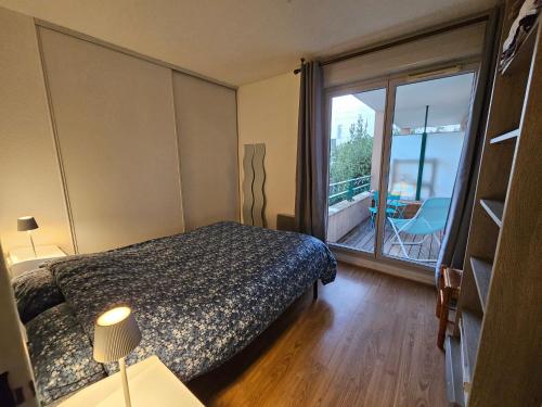 a bedroom with a bed and a view of a balcony at Appartement de charme, Garage, Terrasse, Piscine in Lyon