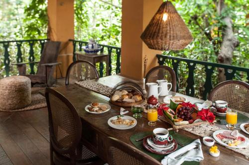 un tavolo con prodotti per la colazione su un balcone di Toca da Coruja a Pipa