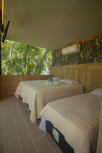 a hotel room with two beds and a window at Rancho Flamboyant Lazer in Lajeado