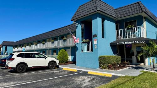a white car parked in front of a hotel building at Hotel Monte Carlo in Kissimmee