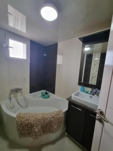 a bathroom with a large tub and a sink at Ferienwohnung Nabeul in Douane
