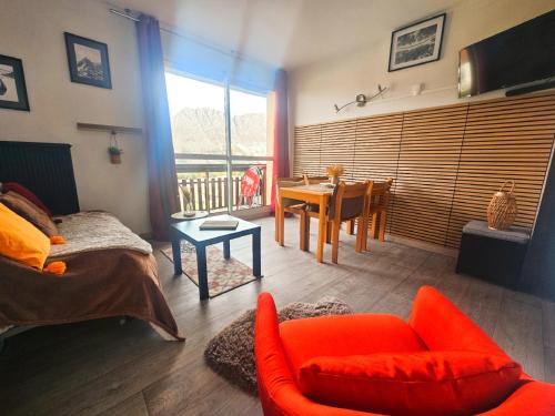 ル・デヴォリュイにあるBois d'aurouze superdevoluy pied des pistes 6 couchagesの赤いソファとテーブルのあるリビングルーム