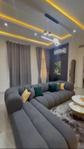 a living room with a large blue couch in a room at Smartlinks apartments in Ikota