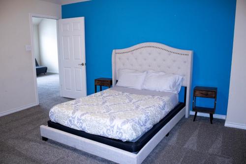a blue bedroom with a bed and a blue wall at Spacious 6 bedroom Home - Gym - Office - Games - Near PGA Frisco & Universal kids in Little Elm