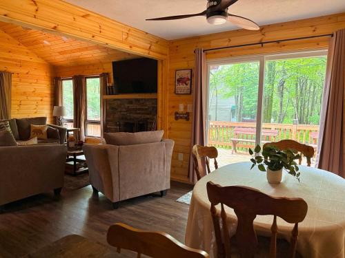 a living room with a table and chairs and a living room at Cozy Poconos Cabin in Blakeslee