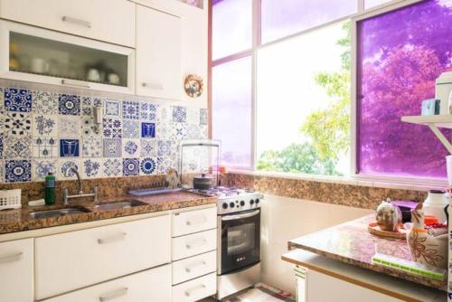 eine Küche mit blauen und weißen Fliesen an der Wand in der Unterkunft Apartamento no Corredor da Vitoria in Salvador