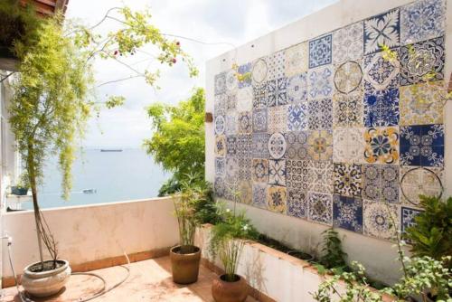 Ein Zimmer mit einer gefliesten Wand und Meerblick in der Unterkunft Apartamento no Corredor da Vitoria in Salvador