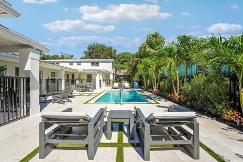 a house with a swimming pool and two patio chairs at Lovely 1 Bedroom - Walk to Waterfront in West Palm Beach